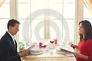 Young couple having romantic dinner in the restaurant viewing menu