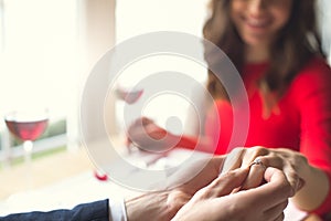 Young couple having romantic dinner in the restaurant wearing a proposal ring blurred