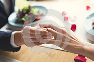 Young couple having romantic dinner in the restaurant wearing a proposal ring close-up