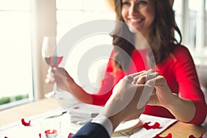 Young couple having romantic dinner in the restaurant wearing a proposal ring smiling