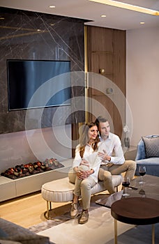 Young couple having a romantic evening with a glass of red wine at home in the contemporary living room