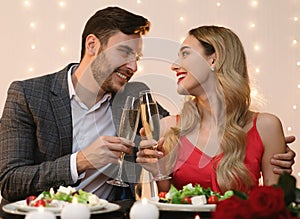 Young Couple Having Romantic Evening In Restaurant, Clinking Glasses With Champagne