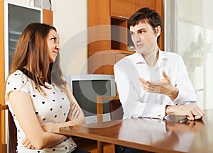 Young couple having serious talking at table