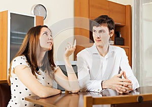 Young couple having serious talking at table