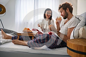 A young couple having a tasty food for a breakfast in the bed. Love, relationship, together