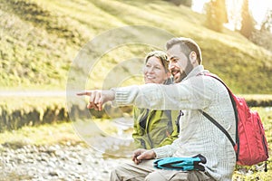 Young couple having trekking day in alps mountains - Trekkers enjoying time together in nature during excursion - Travel,