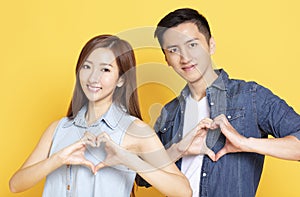 young couple with heart shape hand sign