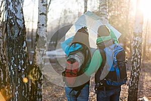 Young couple hikers looking at map.