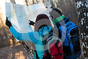 Young couple hikers looking at map.