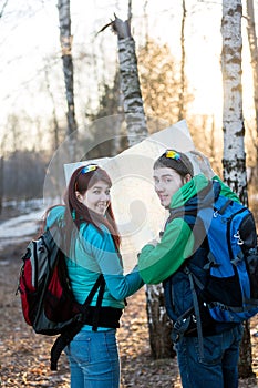 Young couple hikers looking at map.