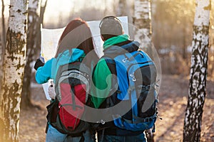 Young couple hikers looking at map.