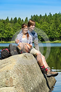 Young couple hikers lounging at lake nature