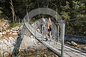 Young couple hiking along a mountain river shore