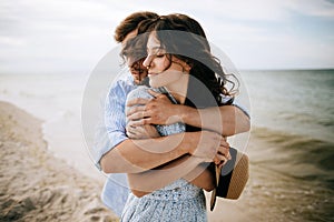 A young couple of hipsters hugging and kissing on a deserted beach. Summer trip