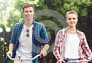 Young couple of hipsters riding a bicycle. Date in old town. Love, relationship, romance concept.