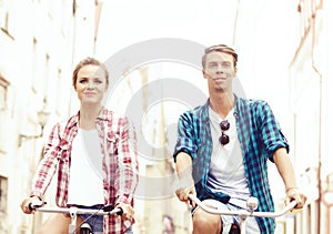 Young couple of hipsters riding a bicycle. Date in old town. Love, relationship, romance concept.
