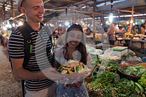 Young Couple Hold Bowl With Vegetables Shopping On Exotic Market Happy Smiling Man And Woman Together On Street Bazaar