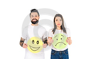young couple holding cards with happy and sad face expressions isolated