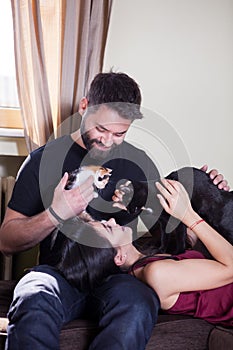 Young couple holding cats in hands