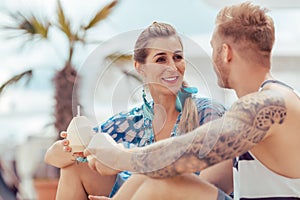 Young couple holding coconut water