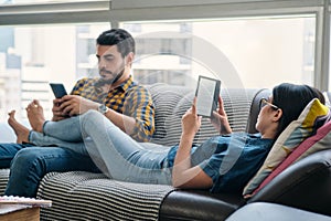 Young Couple Holding Ereader And Reading Ebook