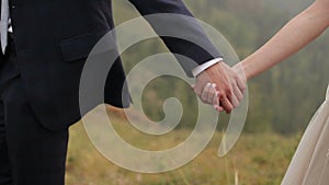 Young couple holding hands groom leading bride walking