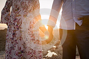 Young couple holding hands at sunset
