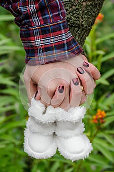 Young couple holding hands with their soon to be born babies shoes