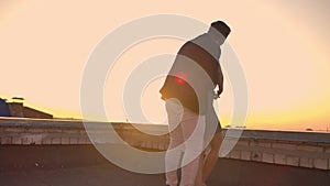Young couple holding hands walking woman leading boyfriend the roof of the building at sunset POV travel concept