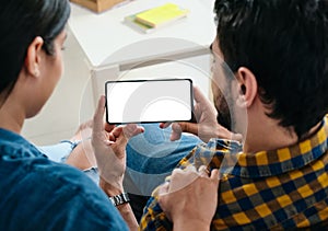 Young Couple Holding Phone With Blank Screen For Copy Space