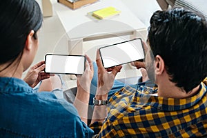 Young Couple Holding Phone With White Screen For Copy Space