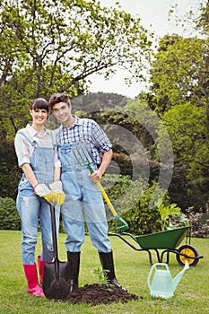 Young couple holding shovel and spading fork