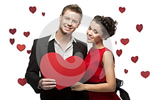 Young couple holding sign in form of red heart
