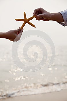 Young Couple Holding Starfish