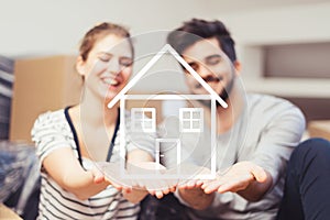 Young couple holding their new, dream home in hands photo