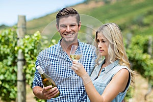 Young couple holding wine bottle and glass