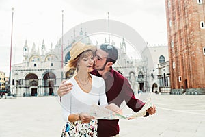 Young couple at holiday in Venice, Italy. Romantic boyfriend and girlfriend holding city map in Piazza San Marco