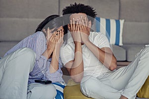 Young couple at home watching a movie with popcorn