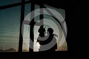 young couple hugging on the background of the window silhouettes of a man and a woman