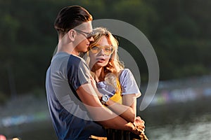 young couple hugging on river beach in evening girlfriend