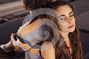 Young couple hugging in the summer daylight on a bridge construction in the city outdoors. copy space