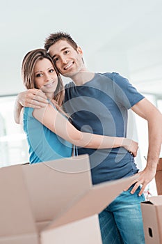 Young couple hugging in their new house