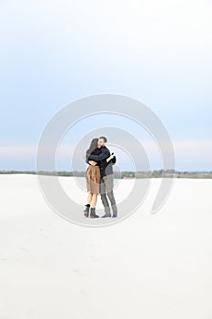 Young couple hugging in white monophonic background.