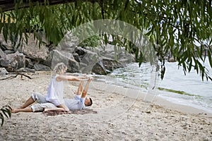 A young couple hugs passionately on the deserted sandy shore. Lifestyle of passionate newlyweds by the ocean. Love, passion and