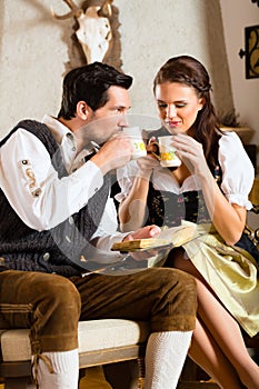 Young couple in a hunter's cabin drinking tea