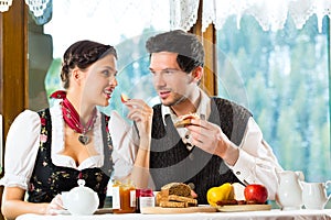 Young couple in a hunter's cabin eating