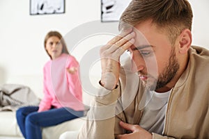 Young couple ignoring each other after argument in living room.