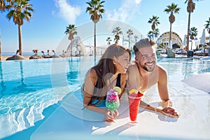 Young couple on infinity pool cocktails