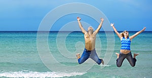 Young couple jumping on the beach