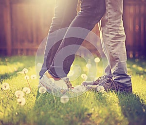 A young couple kissing in a backyard in summer sun light during